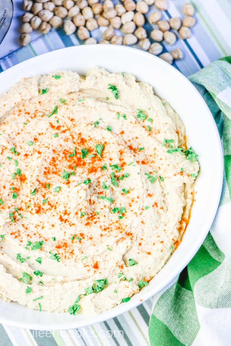 Close up of homemade hummus in a white bowl.