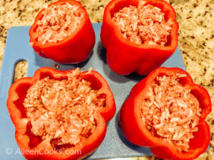 Four red bell peppers filled with ground beef.