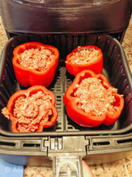 Stuffed bell peppers inside of air fryer.