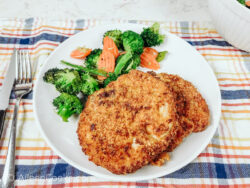 A white plate of crispy air fryer pork chops and mixed vegetables.