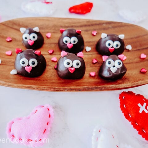 6 chocolate covered strawberry love birds on a wooden tray.