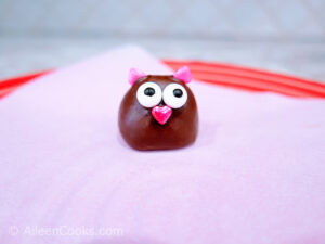 A strawberry decorated as a chocolate love bird.