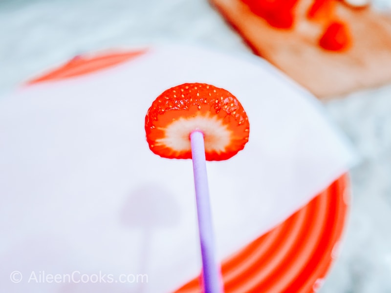 A strawberry on a lollipop stick.