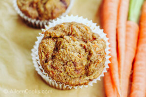 Overhead shot of a carrot muffin next to a bunch of carrots.