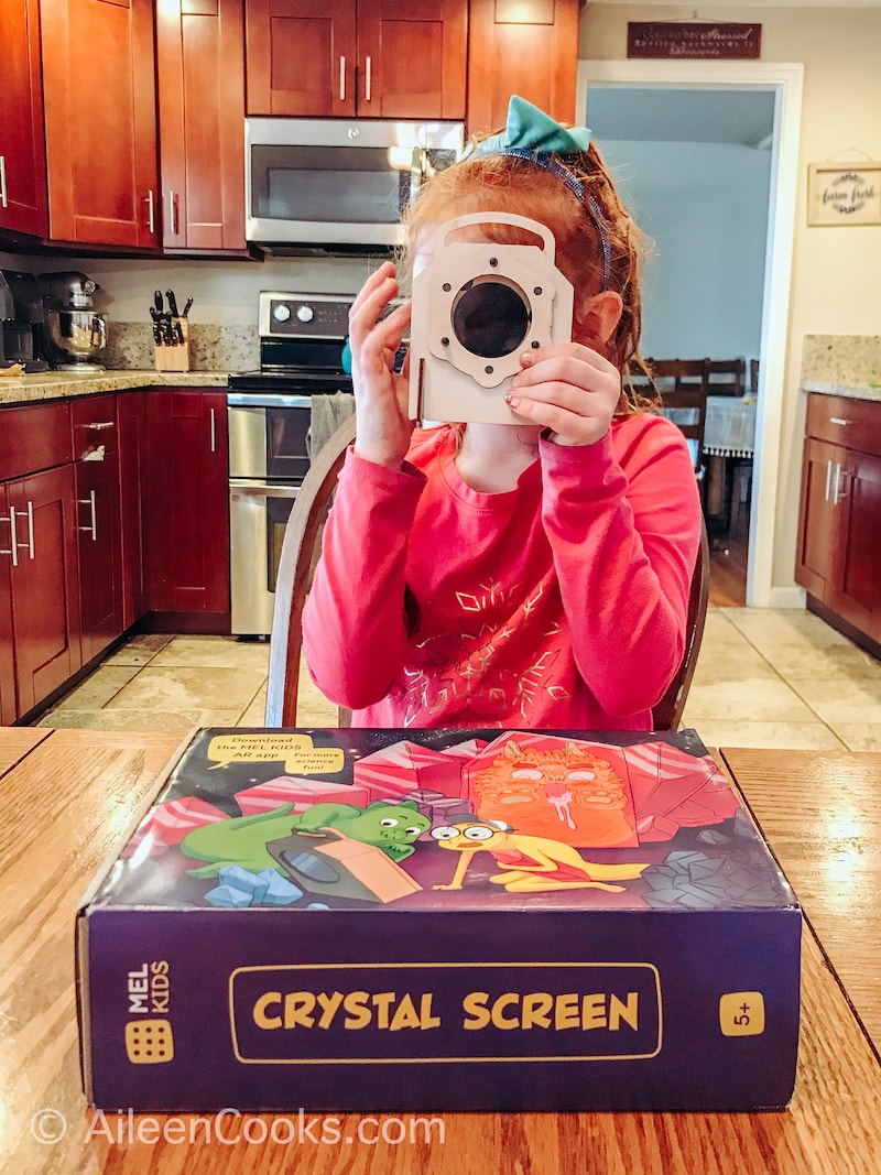 A girl looking through a crystal screen.