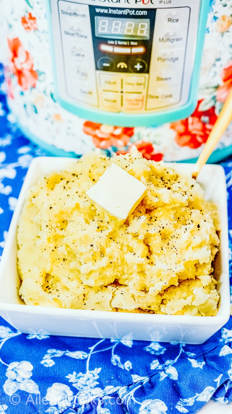 A square dish filled with mashed potatoes sitting in front of an instant pot.