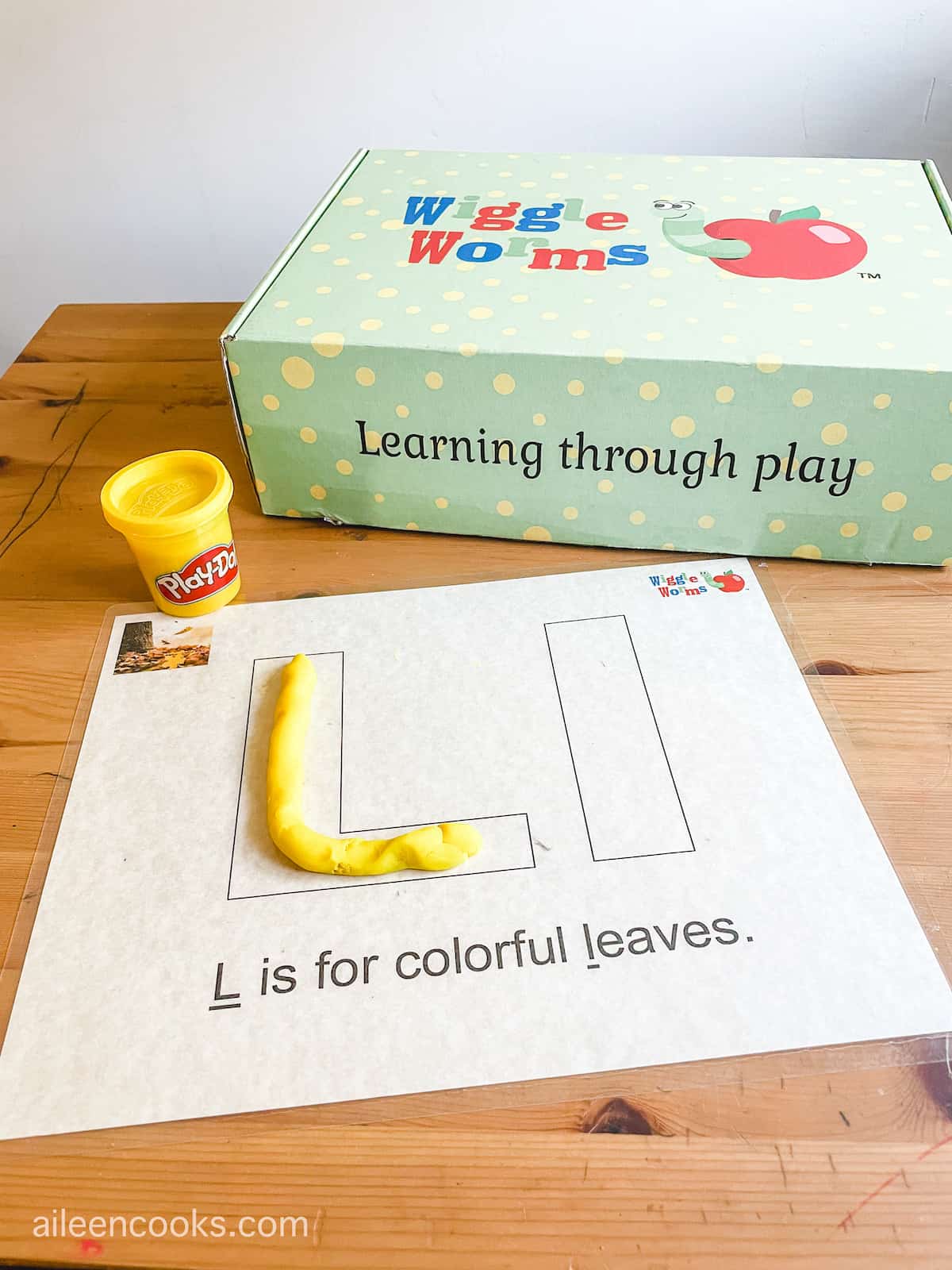 A play dough mat with uppercase and lowercase Ls and yellow play dough.