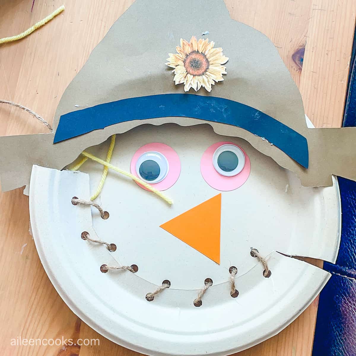 A scarecrow craft made out of a paper plate.
