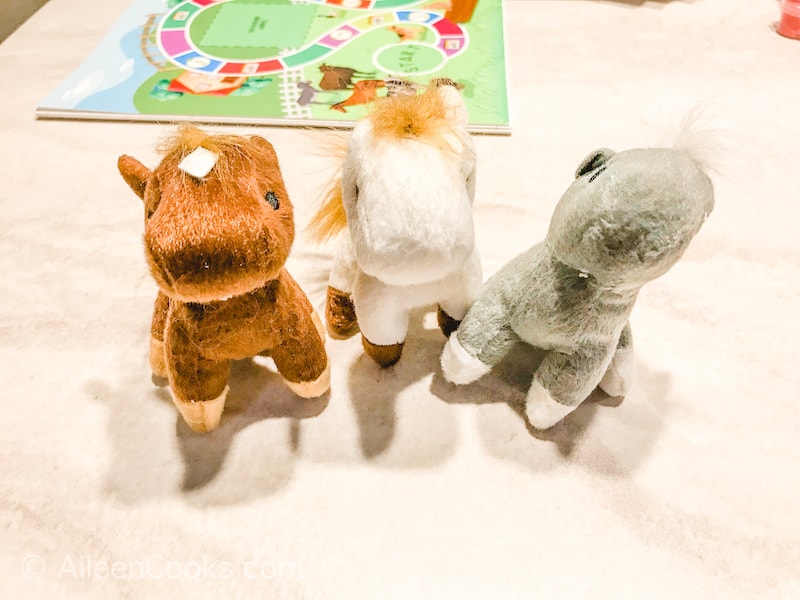 Three small stuffed animals on a white tabletop.