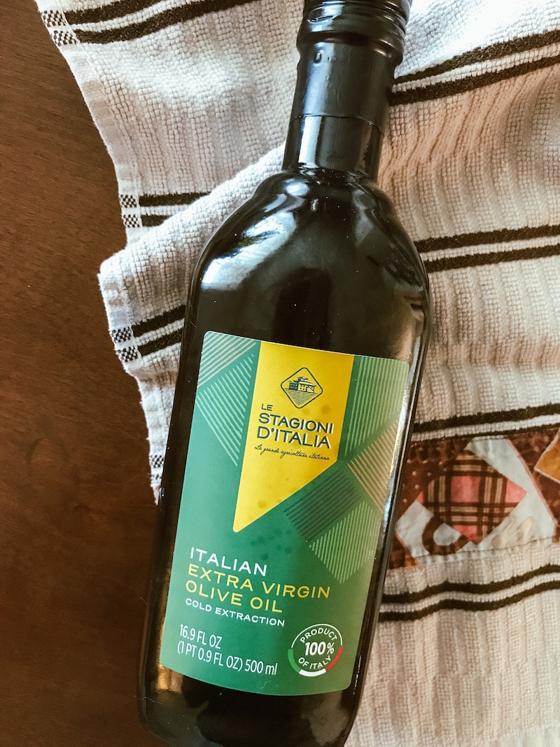 Bottle of olive oil on a white striped towel.