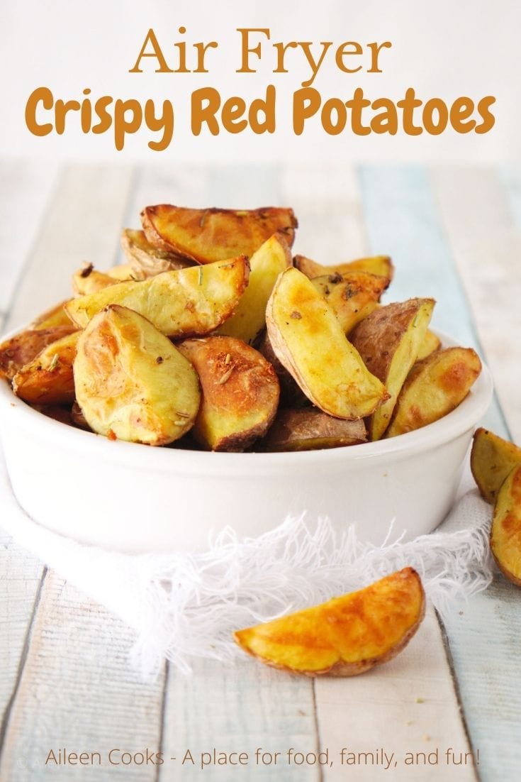 A white bowl filled with red potato wedges and the words "Air Fryer Crispy Red Potatoes" in brown lettering.