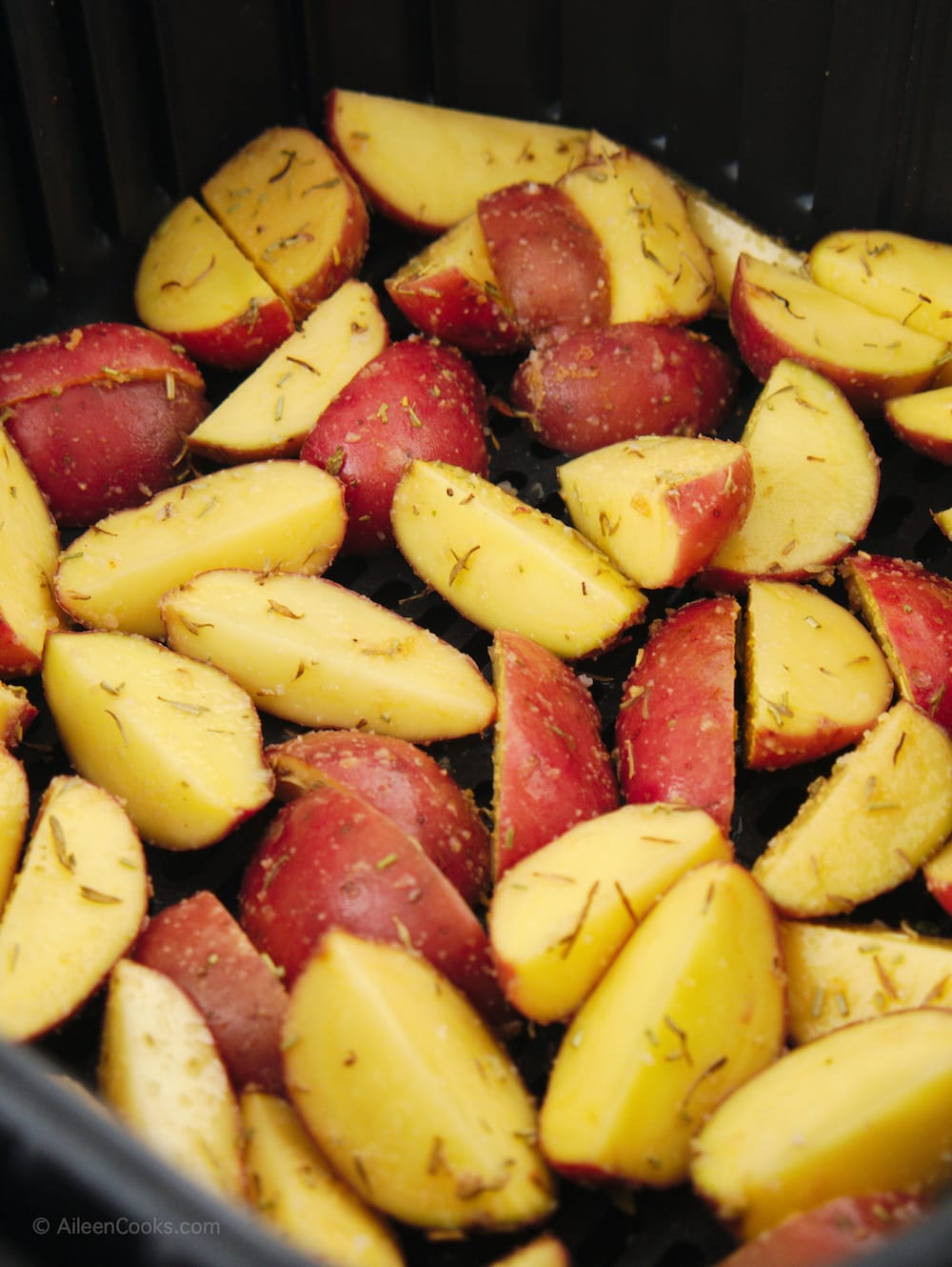 Quartered red potatoes coated in dried rosemary.