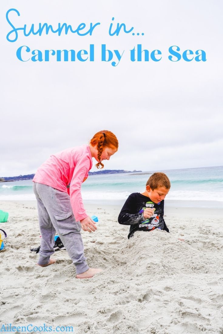 Two kids digging in the sand at Carmel Beach.