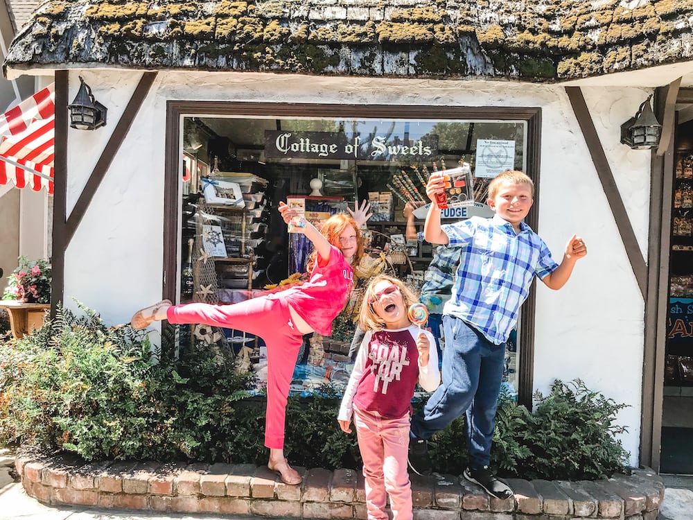 Three kids standing in front of the Cottage of Sweets in Carmel-by-the-Sea.