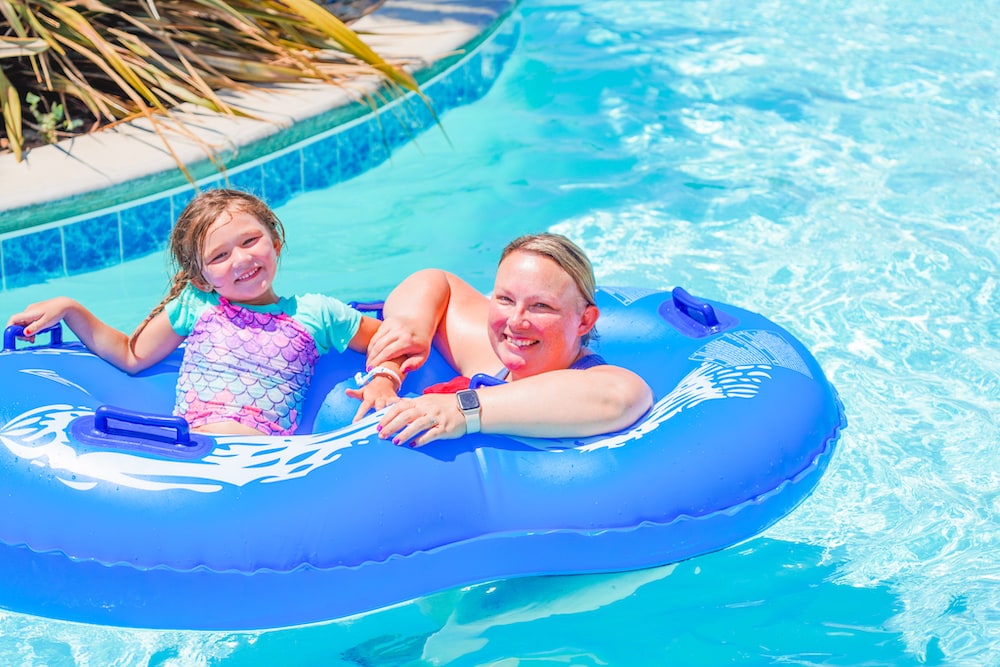 A mother and daughter sitting in a double tube on the lazy river at Tower Park Camp-Resort.