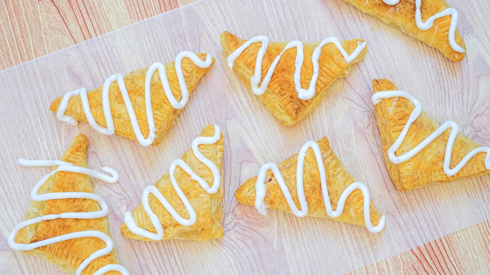 A sheet of parchment paper topped with pumpkin hand pies.