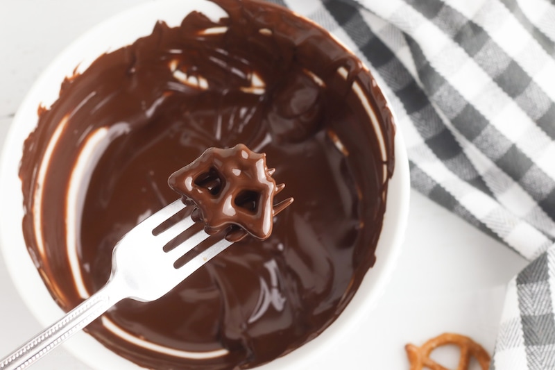 A bat shaped pretzel dipped in melted chocolate.