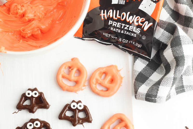 Halloween decorated pretzels on a white counter.