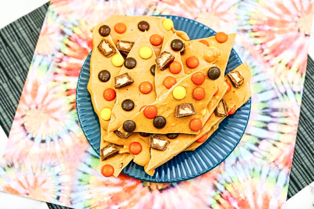 A blue plate loaded with peanut butter cup bark candy.