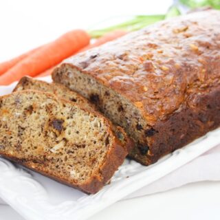 A loaf of carrot bread on a white platter.