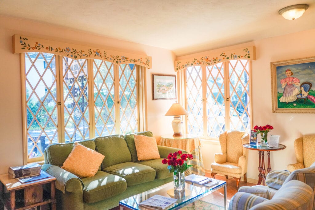 A couch and chair under a sunny window