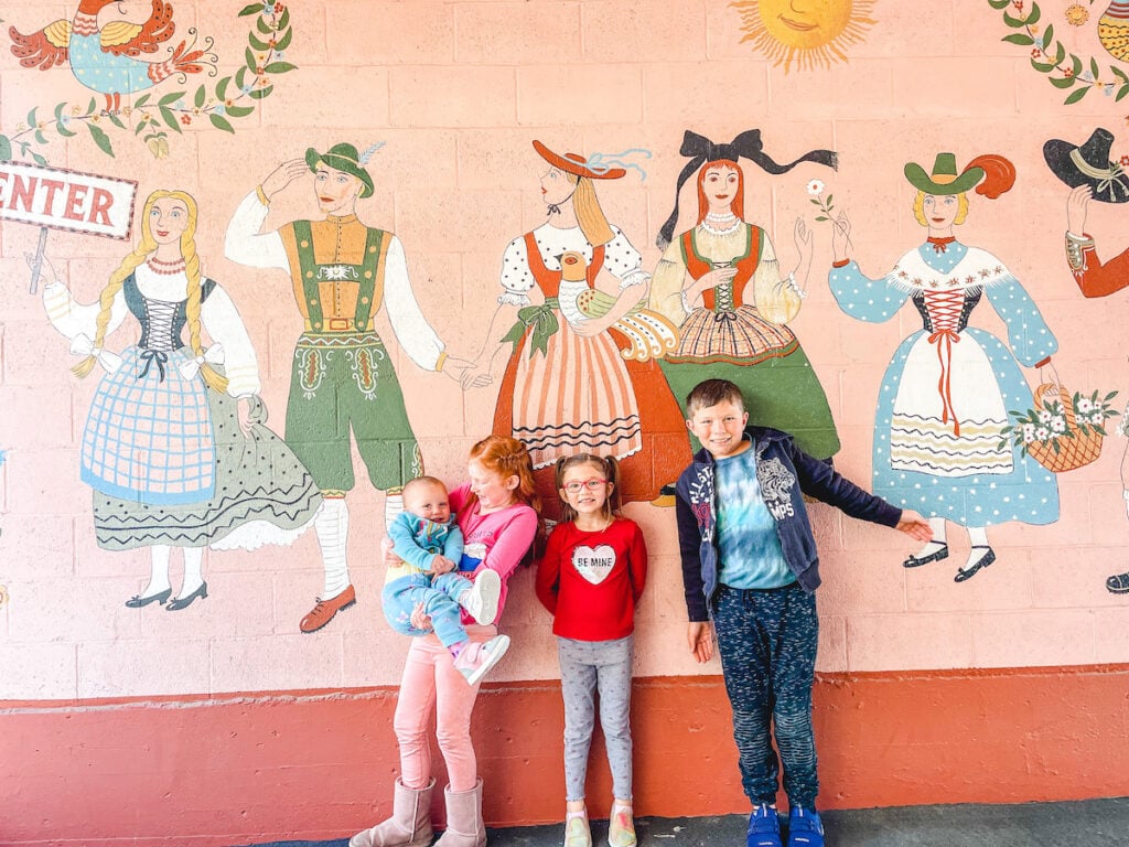 Four kids standing in front of a mural at Hofsas House Hotel.