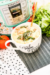 A white mug bowl filled with tortellini soup in front of a teal instant pot.