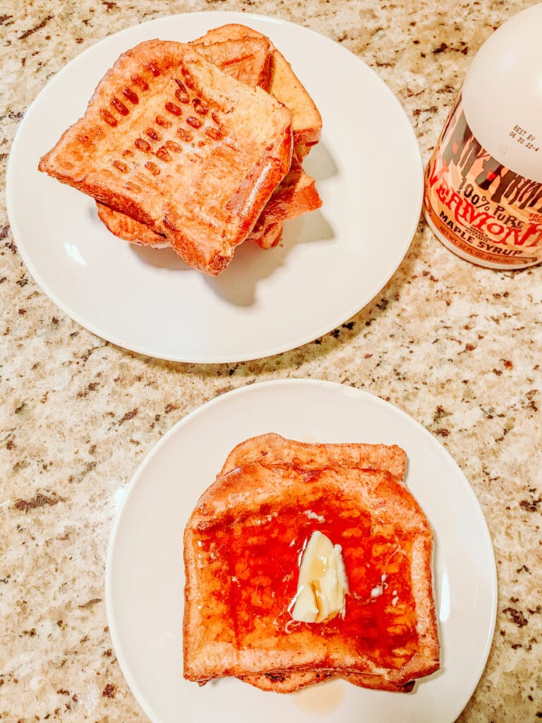 Two plates of French toast on white plates.