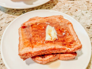 A stack of French toast on a white plate.