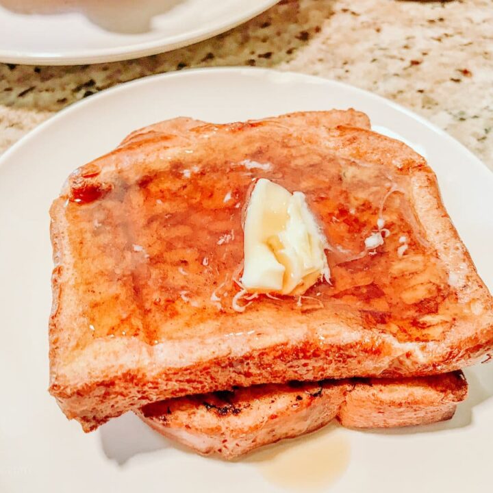 A stack of French toast on a white plate.