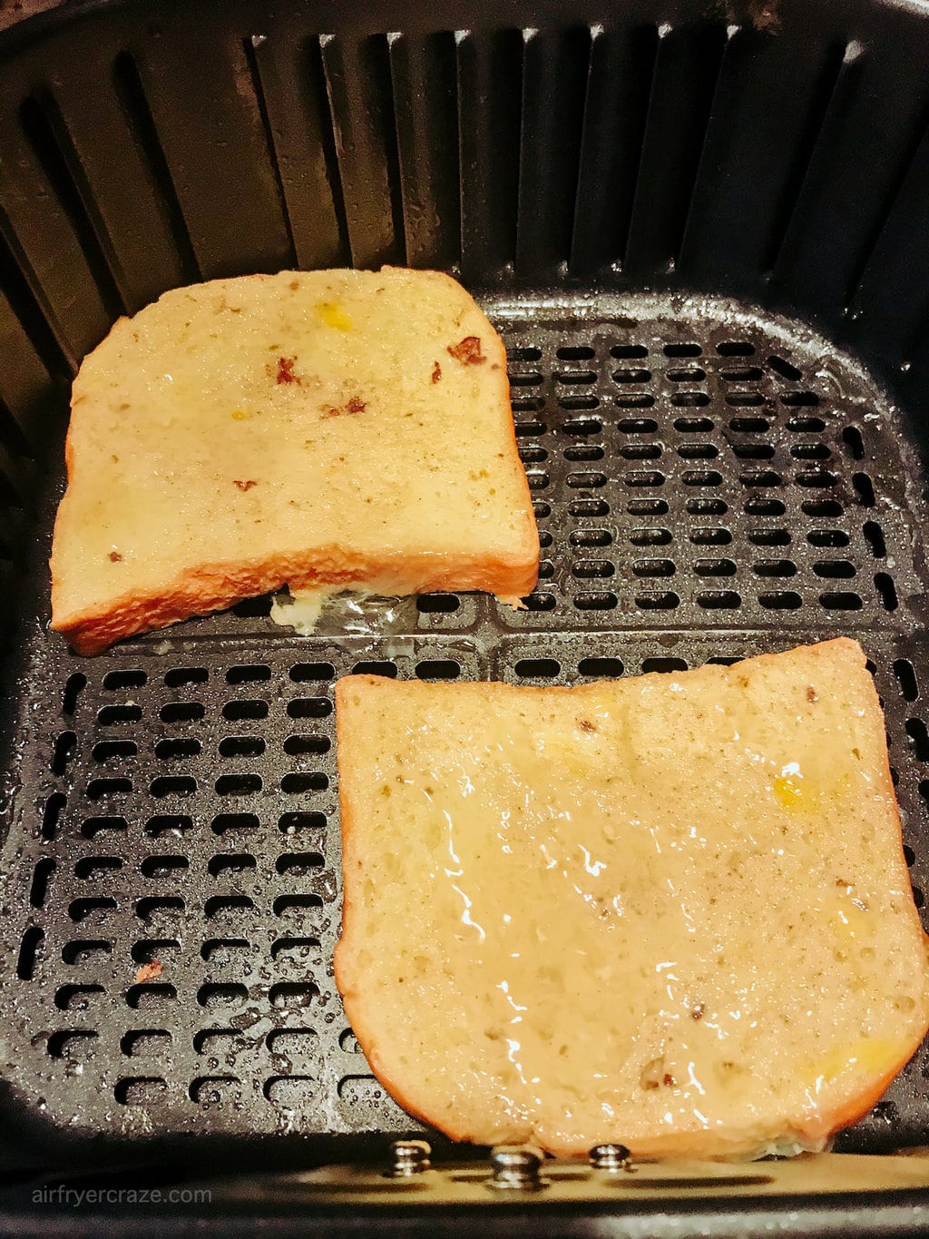 Two slices of egg coated toast inside an air fryer.