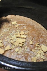 Newly-baked cake in a Crockpot, topped with graham cracker crumbs