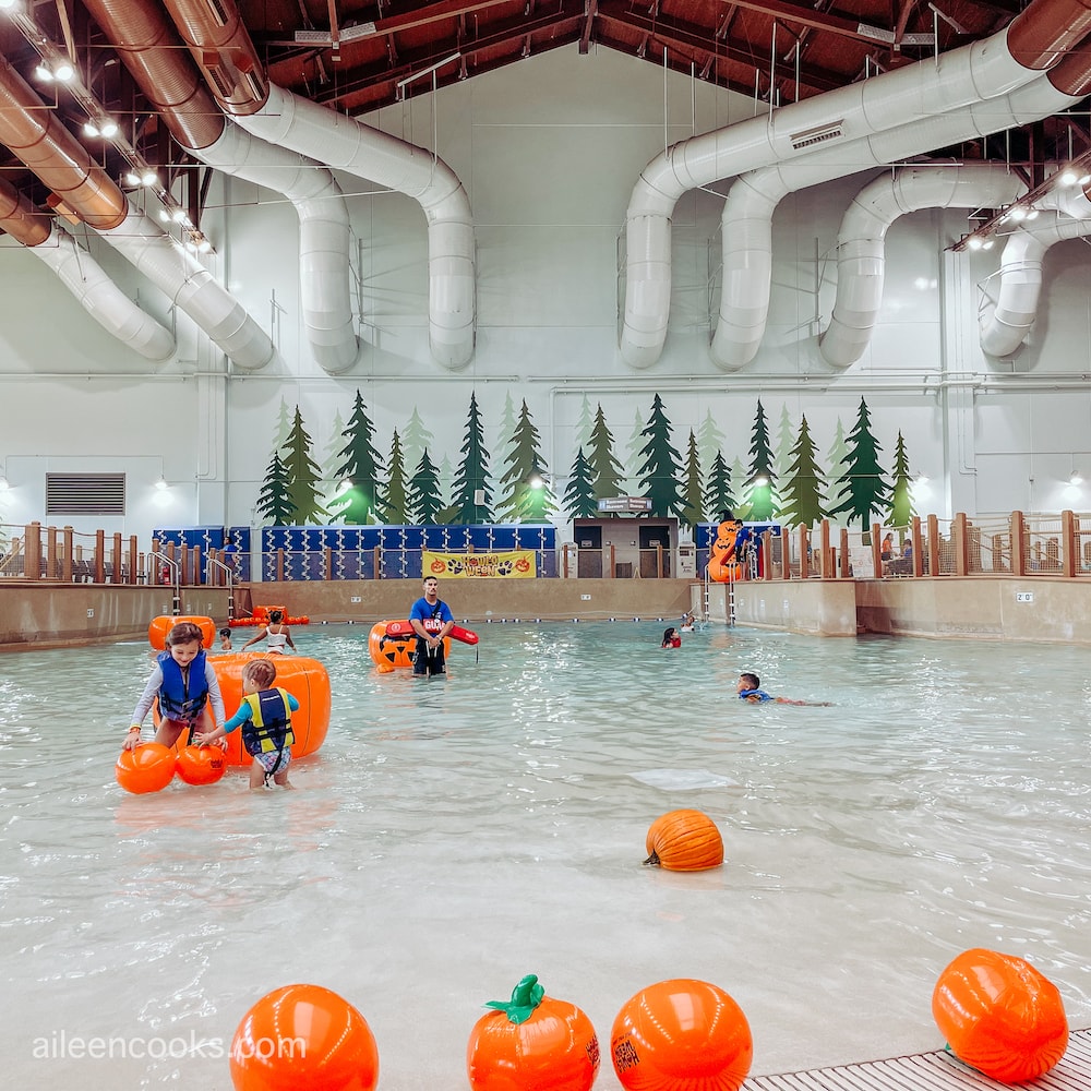 A large pool filled with real pumpkins and inflatable pumpkins.