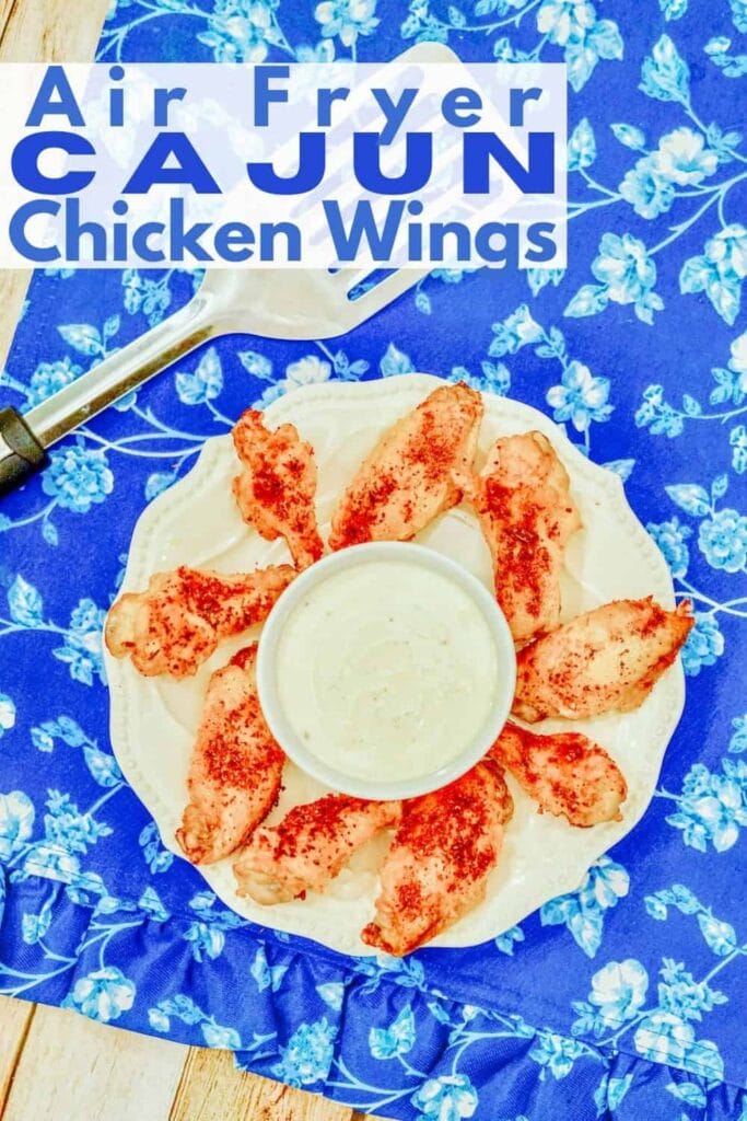 A blue flowered tablecloth topped with a plate of chicken wings.