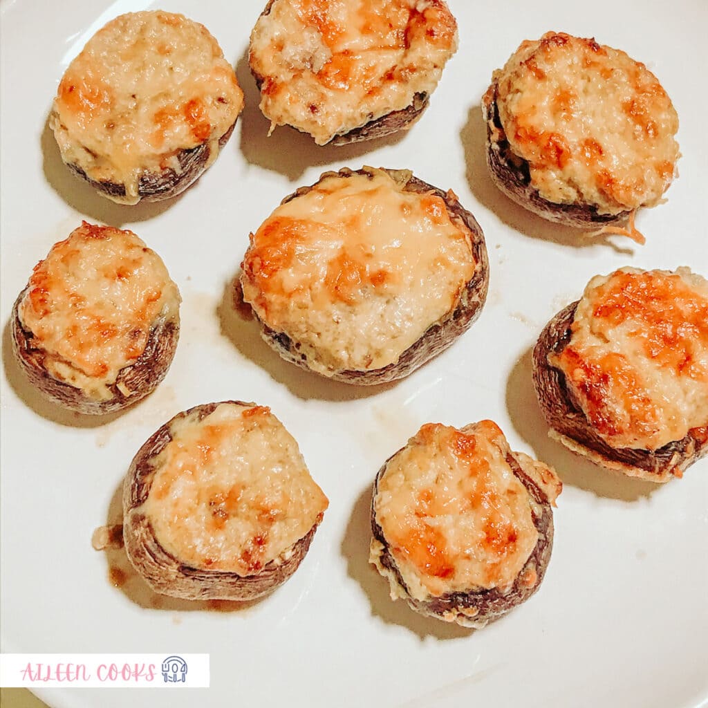 A close-up shot of air fryer stuffed mushrooms placed on a white plate