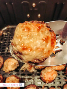 An air fryer stuffed mushroom coming out of the air fryer, newly baked