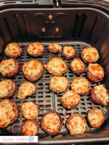 Stuffed mushrooms, sitting in the air fryer basket, newly baked