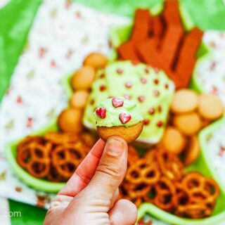 A cookie being held by a hand, freshly dipped in Christmas Cookie Dip