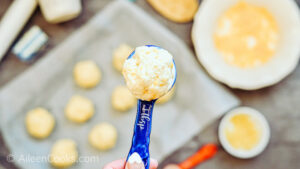A close-up photo of biscuit batter in a blue measuring spoon.