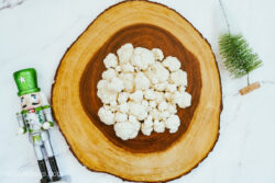 Cauliflower on a wooden tray, sitting on a marble countertop