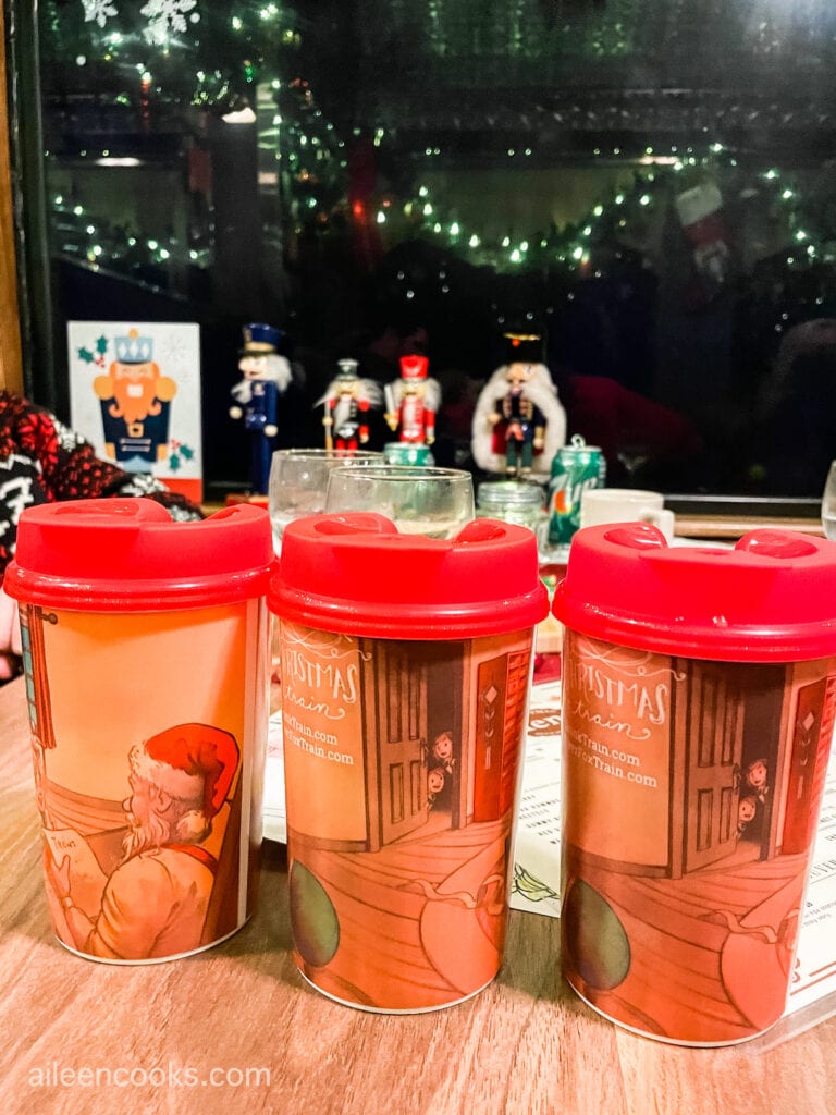 Three Christmas themed cups with lids.