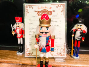 Three nutcrackers posed in front of a menu.