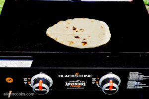 A piece of naan bread sits on a grill
