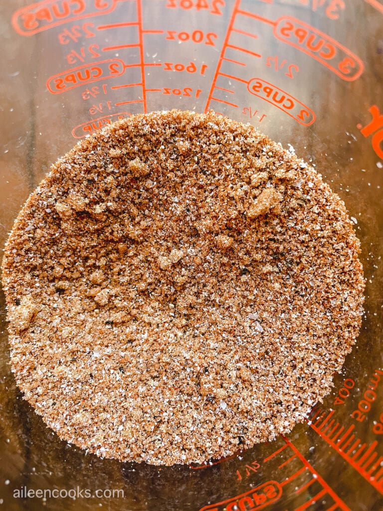 Homemade rib rub mixed up inside of a glass measuring cup.